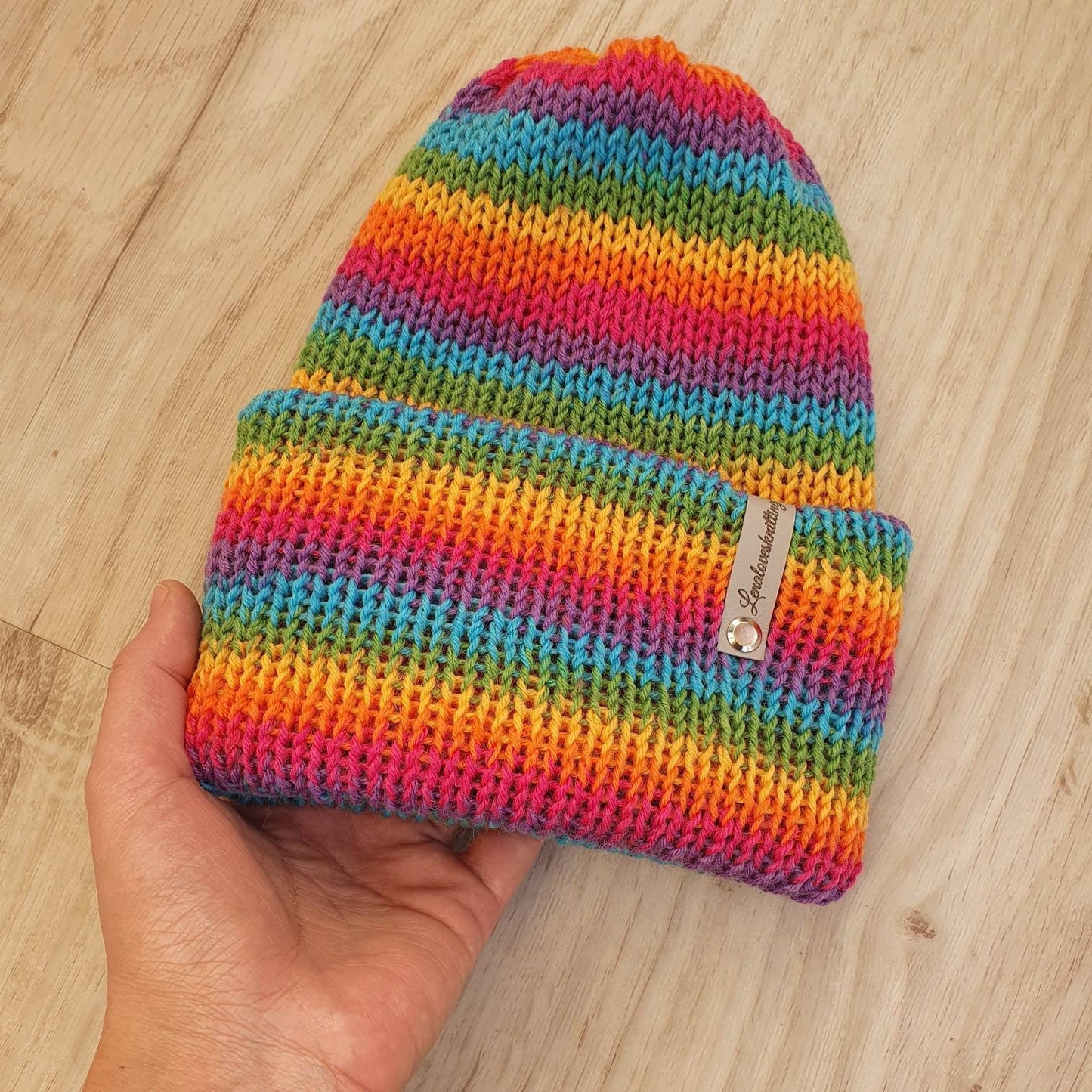 Gestrickte Mütze in Regenbogen-Farben